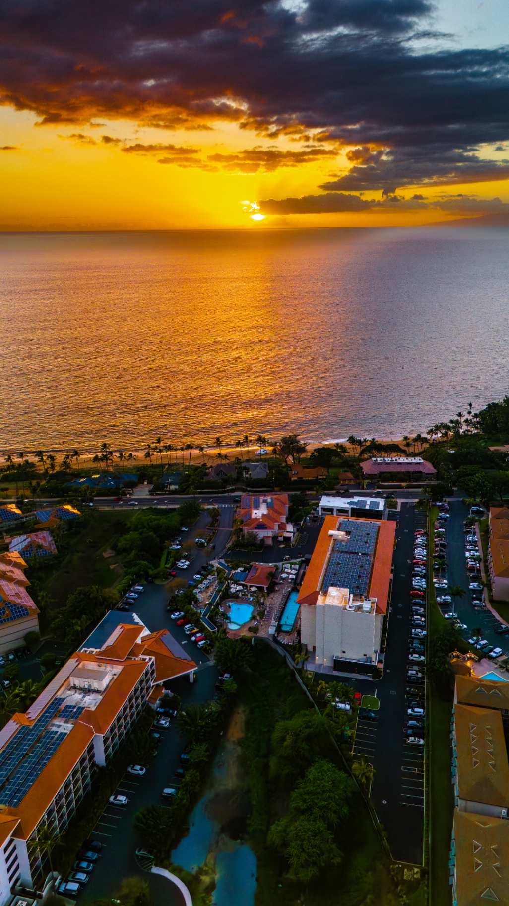 Aerial sunset over the Kihei coastline and the Maui Coast Hotel rooftops and pools